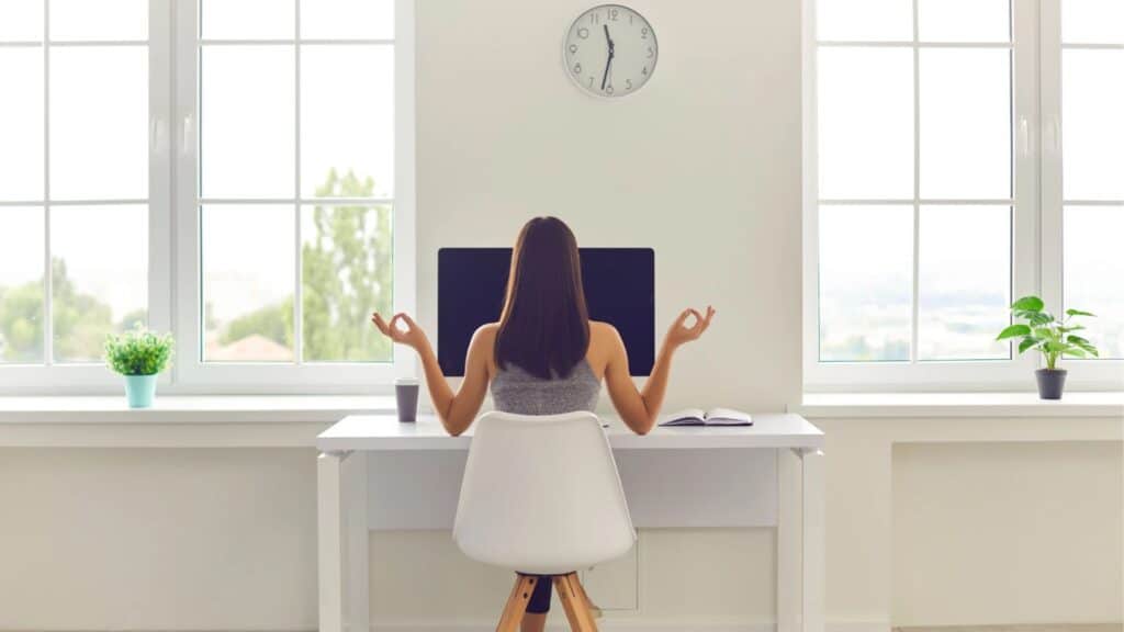 femme de dos qui médite devant son ordinateur